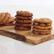 Load image into Gallery viewer, Stacks of chocolate chip, salted caramel and oatmeal raison cookies on wooden platter
