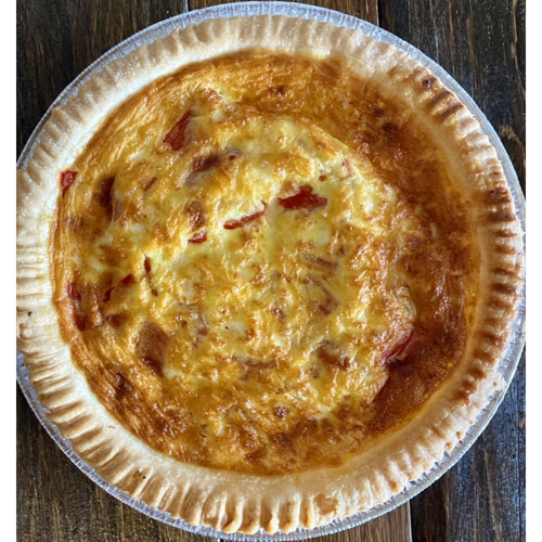 Roasted red pepper and goat cheese quiche on table