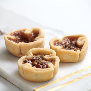 3 butter tarts placed on white decorative tray