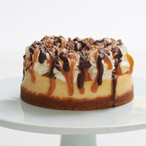 Cheesecake topped with chocolate, caramel, pecans and whip cream
