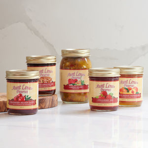 Assortment of Aunt Lena's Preservers jars on marble background