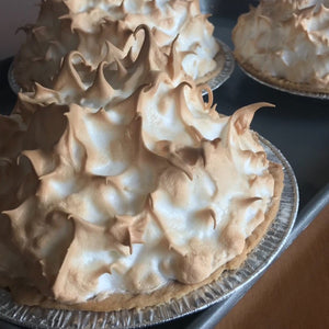 Several lemon meringue pies on table